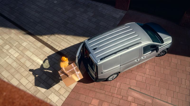 VW Caddy Maxi wird mit Paketen beladen.