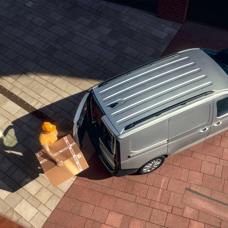 VW Caddy Maxi wird mit Paketen beladen.