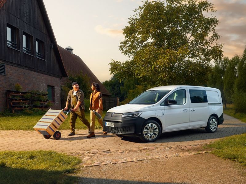 Ein VW Caddy Cargo parkt auf einem Hof.