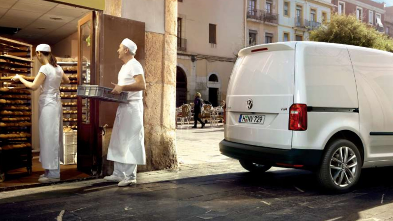 Two bakers loading trays into a VW Transporter