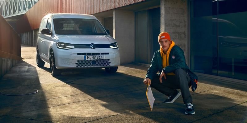 Le nouveau Volkswagen Caddy Cargo devant un complexe de bureaux moderne.