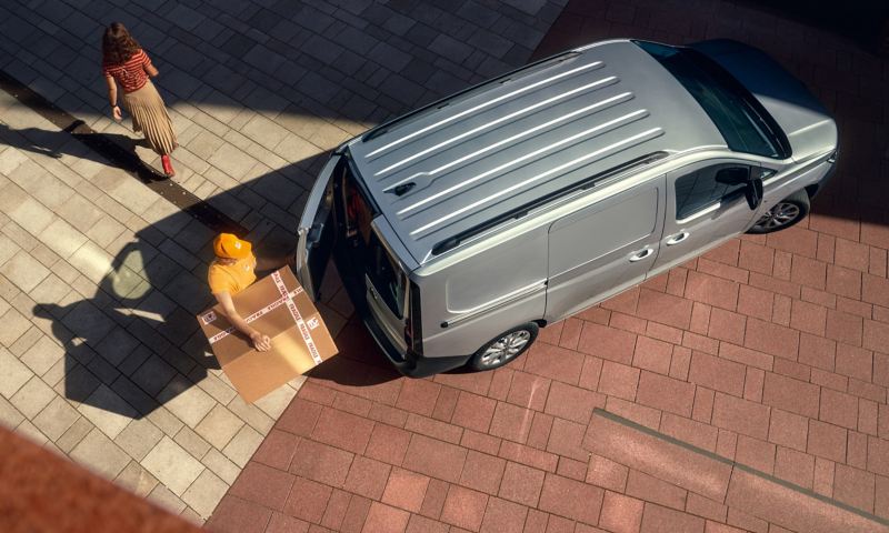A delivery man retrieving a parcel from the Caddy Cargo
