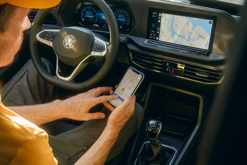 El VW Nuevo California aparcado en la orilla junto a dos personas.