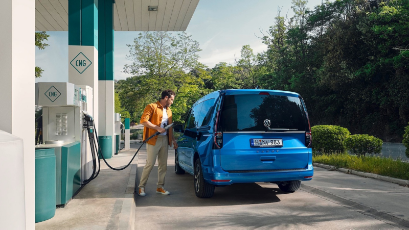 El VW Nuevo California aparcado en la orilla junto a dos personas.