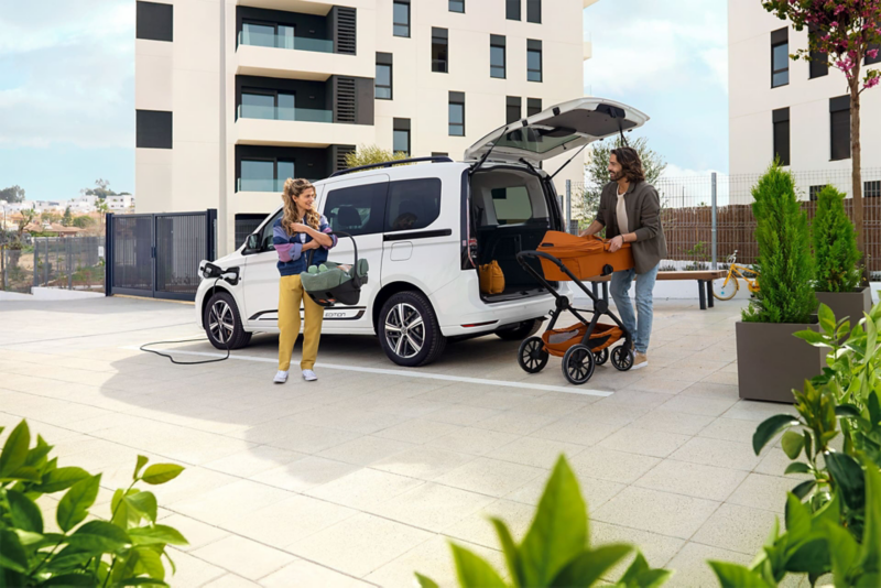 Widok na VW Caddy z silnikiem PHEV, podpiętego do ładowarki