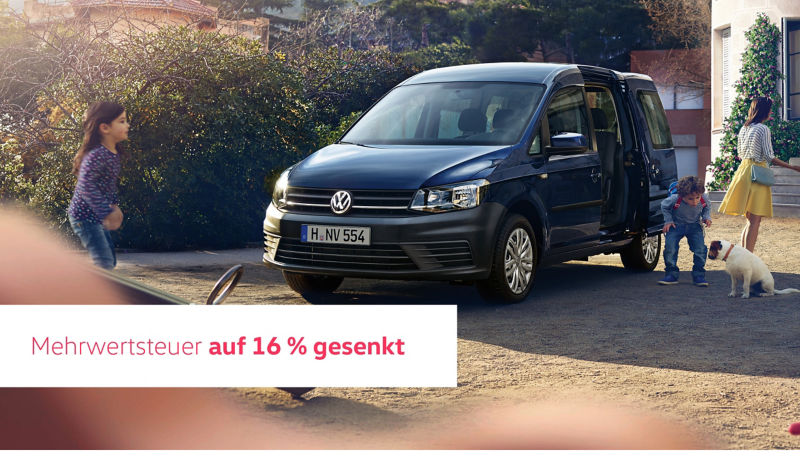 Ein blauer Caddy vor einer Schule. Eine Mutter nimmt nach Schulschluss Ihren Sohn in Empfang. 