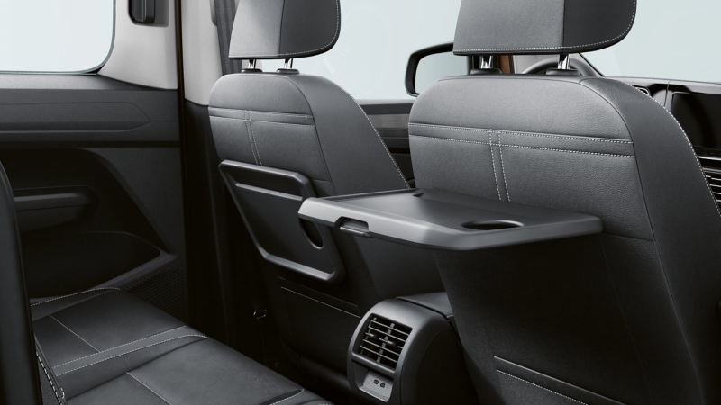Dettaglio del tavolino ribaltabile sul lato posteriore del sedile del passeggero anteriore montato su Caddy Volkswagen.