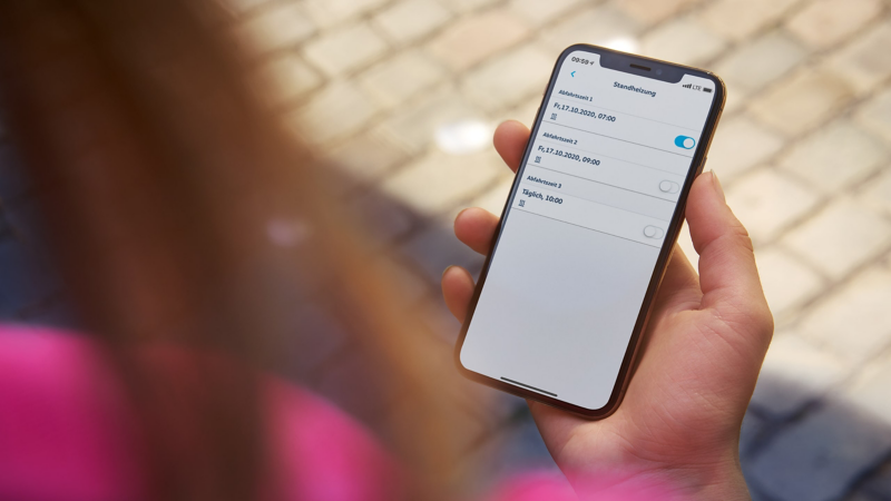 Een vrouw heeft de We Connect-app geopend voor de online standverwarming.