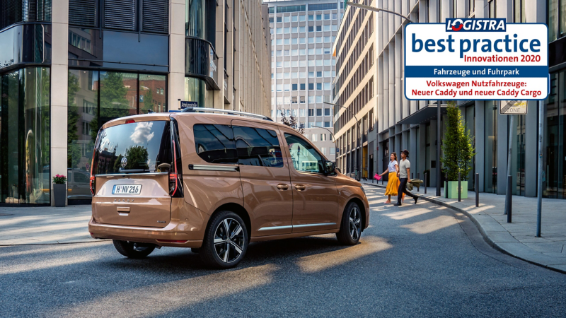 The VW Caddy drives through a city.