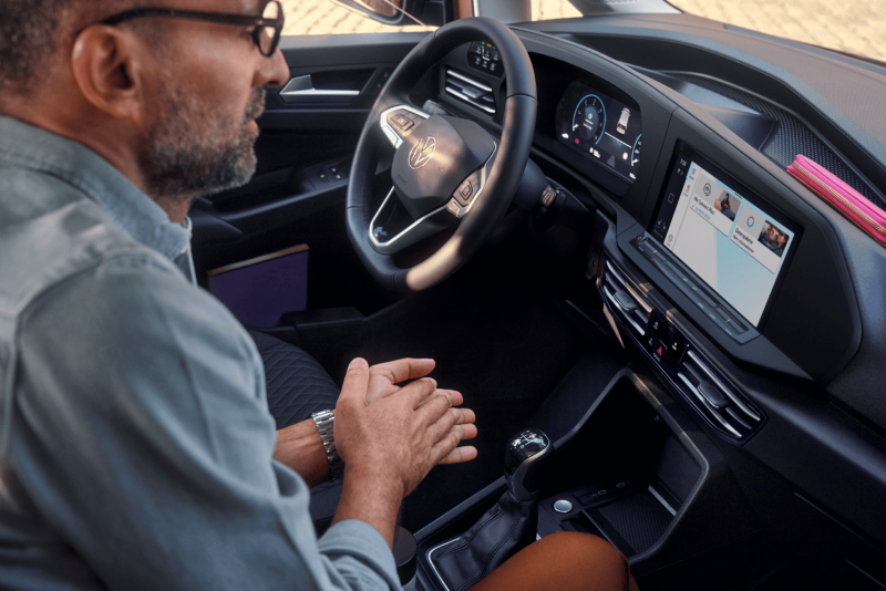 Mężczyzna patrzy na kokpit Volkswagena Caddy.