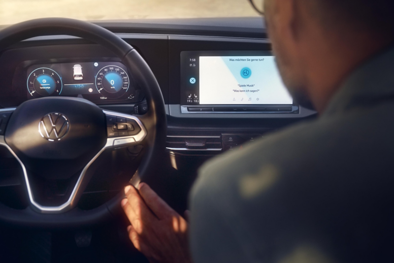 El VW Nuevo California aparcado en la orilla junto a dos personas.