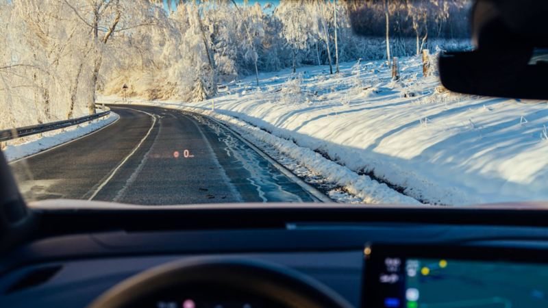 Vue sur la route enneigée depuis le tableau de bord d'une Volkswagen.