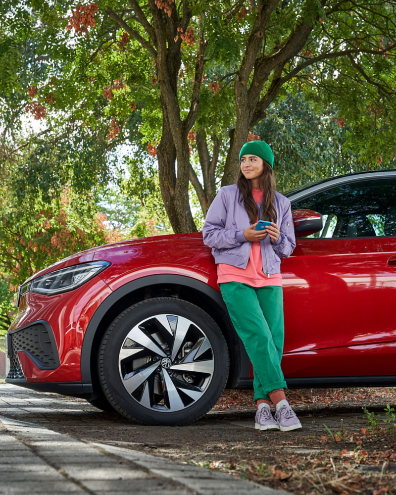 Young woman in front of electric vehicle.