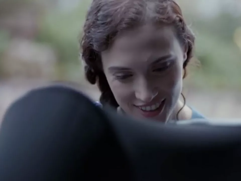 Close up of a woman putting a child into a baby seat