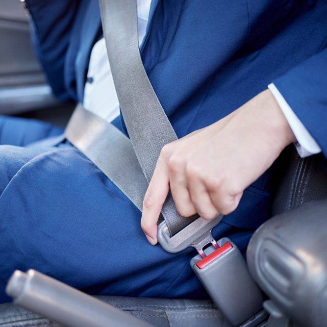 Hombre en traje poniéndose un cinturón de seguridad en un coche