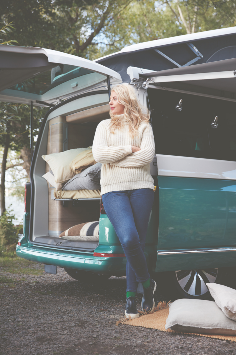 Personer står lutad mot en campervan.