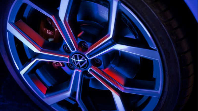 Detalle de una llanta Volkswagen iluminada por luces azules y rojas