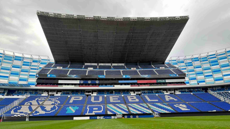 Interior del Estadio Cuauhtémoc de la ciudad de Puebla, con escudo y nombre del equipo en gradas.