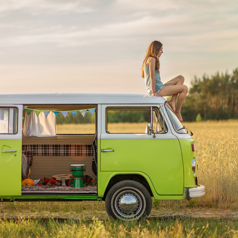 mujer joven disfrutando paisaje en combi vw verde