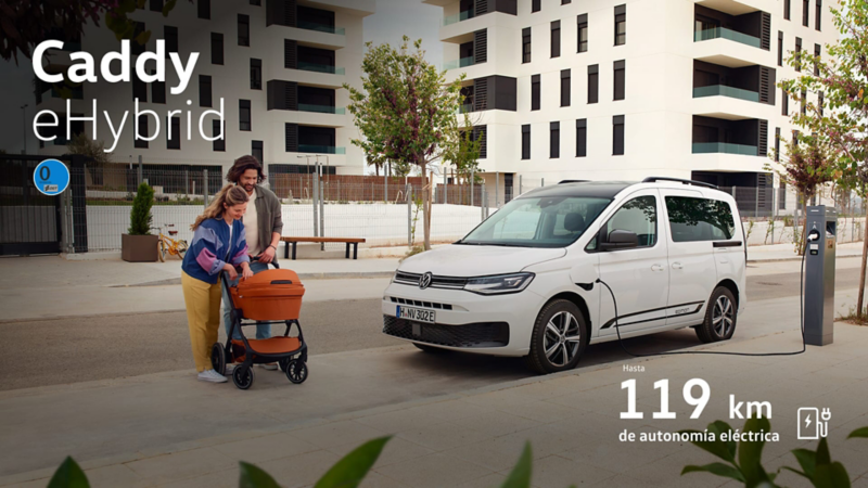 Vista lateral y medio frontal del nuevo Caddy eHybrid blanco junto a una pareja con un carrito de bebé y promoción