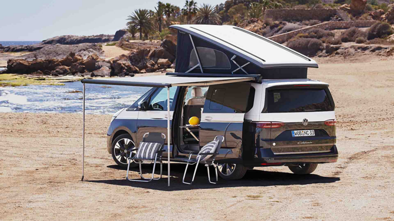 Una nueva California aparcada en una playa con los techos abiertos