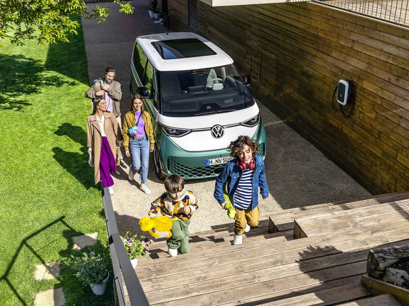 El VW ID. Buzz aparcado en una casa con personas alrededor