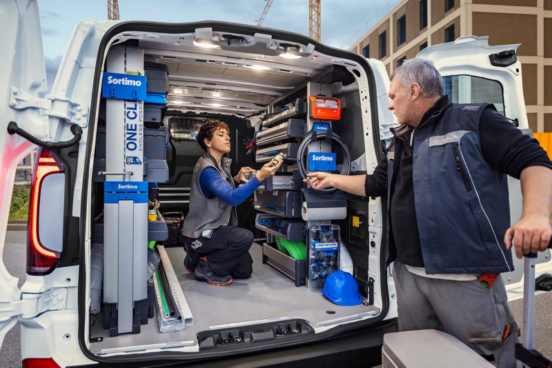 Un Transporter con el portón trasero abierto mientras dos trabajadores lo cargan