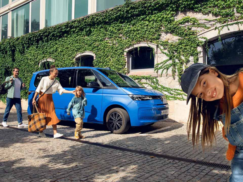 Un hombre y su perro en el bosque, saliendo del VW Nuevo California.