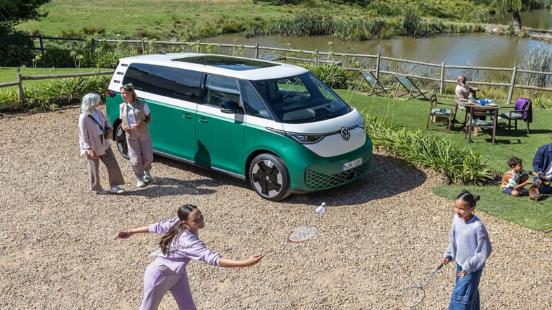 Una familia junto a un Volkswagen ID. Buzz en el campo