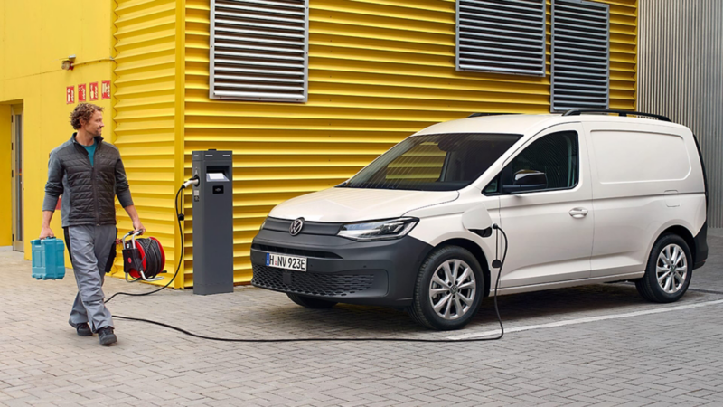Una persona con herramientas junto a un Volkswagen Caddy Cargo blanca