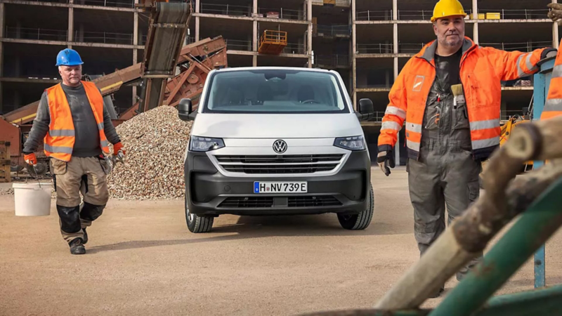 Dos trabajadores junto a un Volkswagen Transporter Kombi