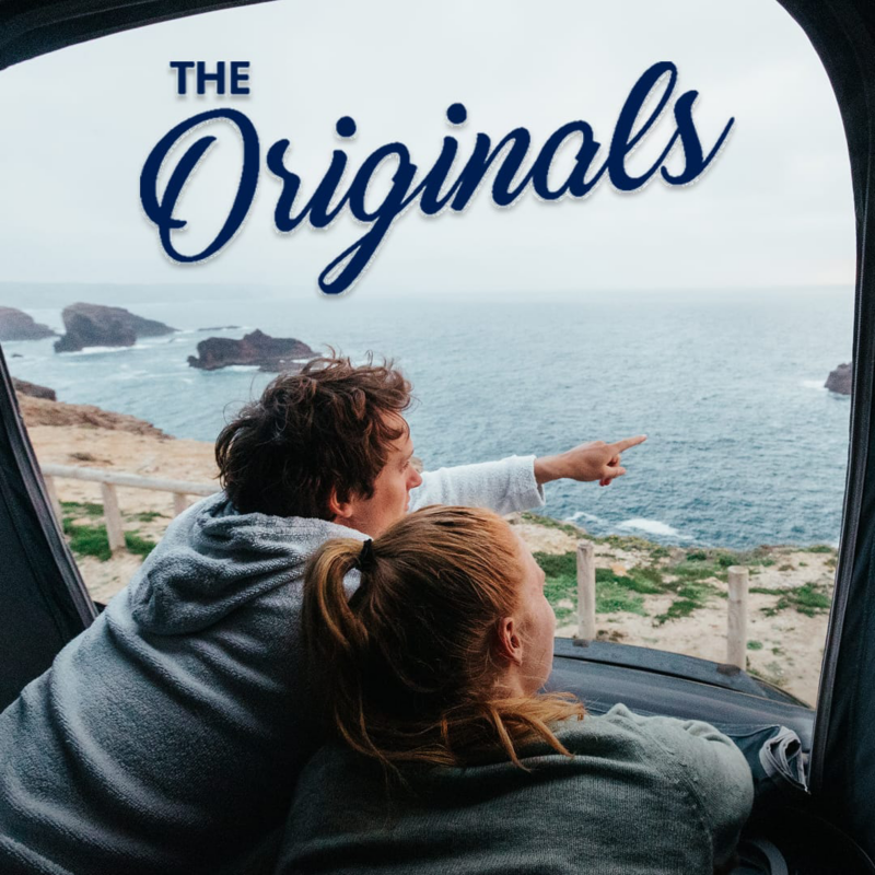 Una pareja mirando a través de una ventana de una furgo Volkswagen y la palabra The Originals