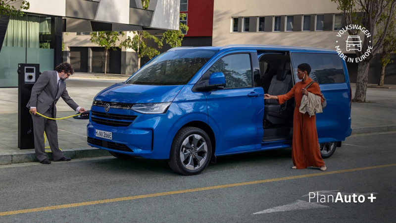 Una furgoneta Volkswagen Transporter color azul en su estación de carga gratuita con Plan Auto Plus