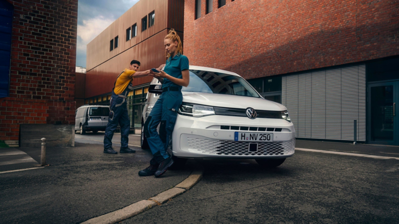 Dos personas apoyadas en una furgo de Volkswagen en la calle