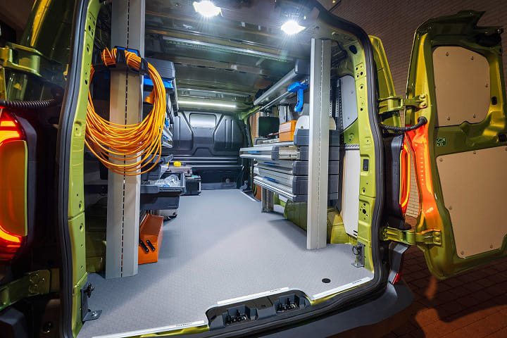Portón de una furgo Volkswagen abierto con materiales de trabajo