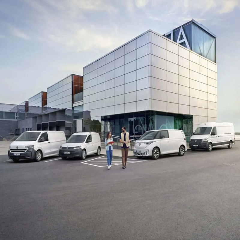 Furgonetas profesionales de Volkswagen aparcadas en un ambiente de trabajo y personas delante