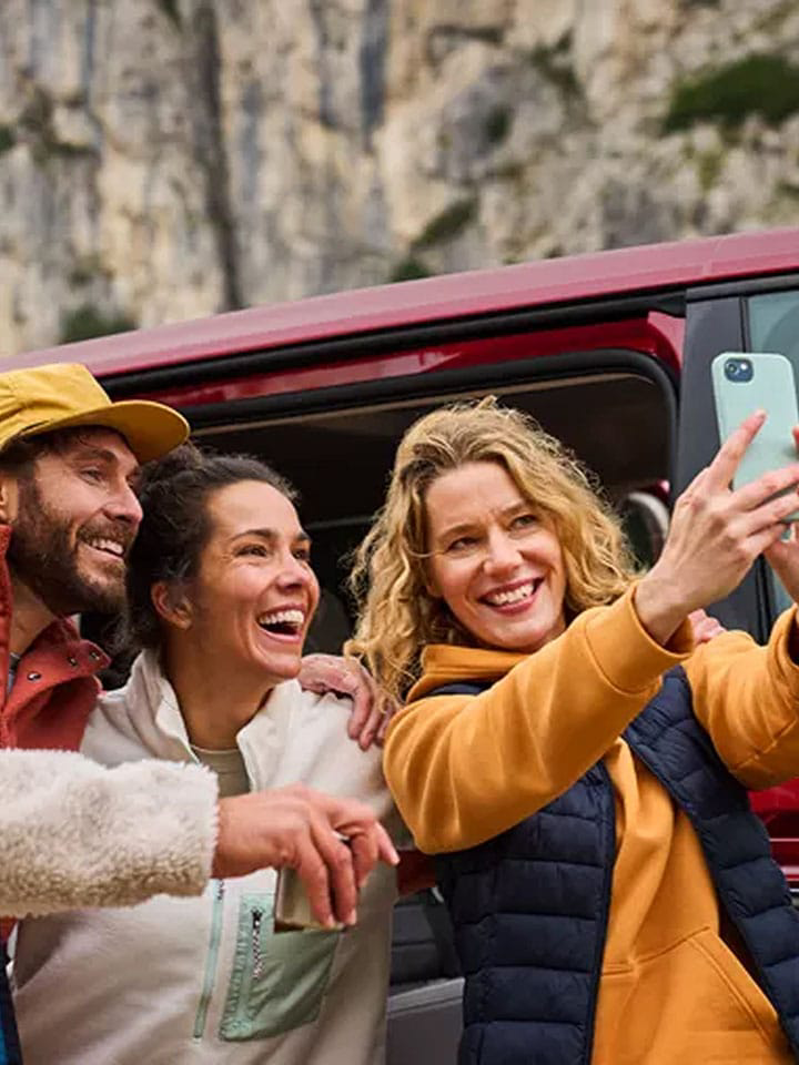 Personas haciendose una selfie delante de su furgo Volkswagen