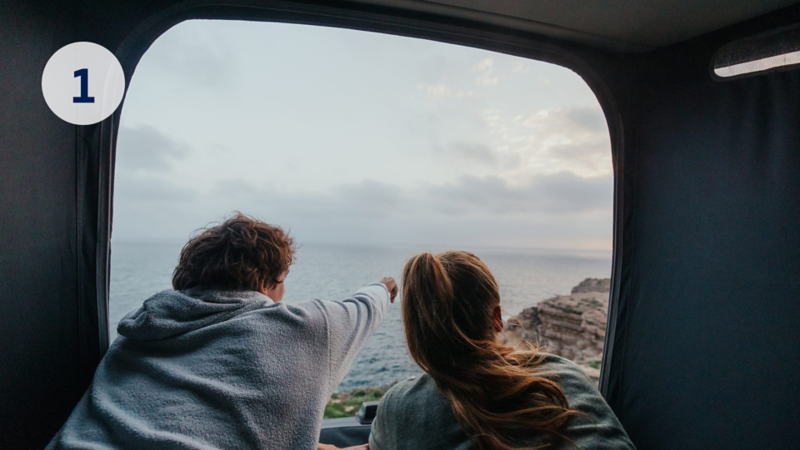 Dos personas mirando por la ventana de su furgo Volkswagen