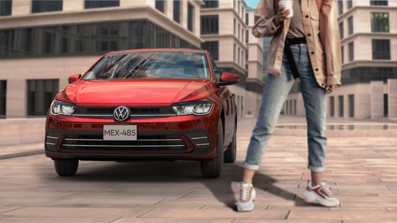 Mujer posa frente a un auto Polo Volkswagen de color rojo. 
