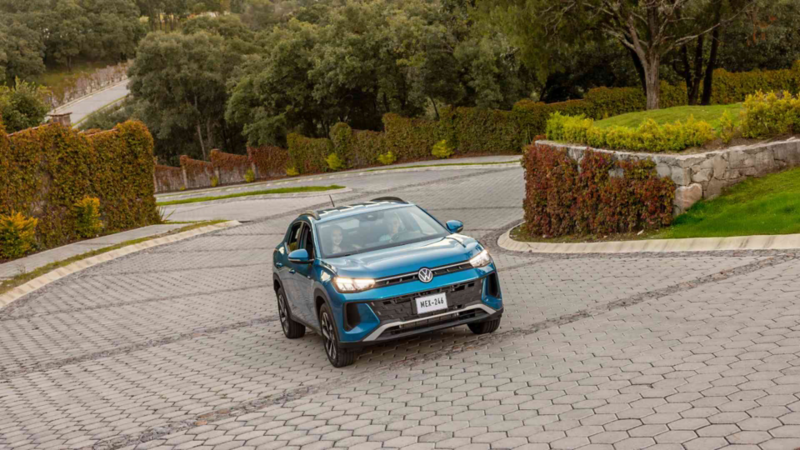 Camioneta SUV de Volkswagen sube un camino adoquinado y rodeado de área verde. 