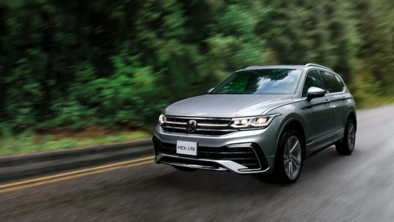 Camioneta Tiguan de Volkswagen dentro de una carretera boscosa. 