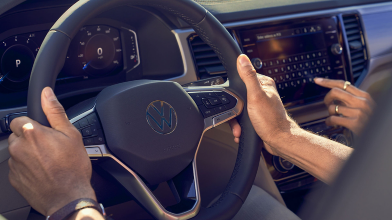 Volante de auto Volkswagen. Conductor manejando vehículo. 