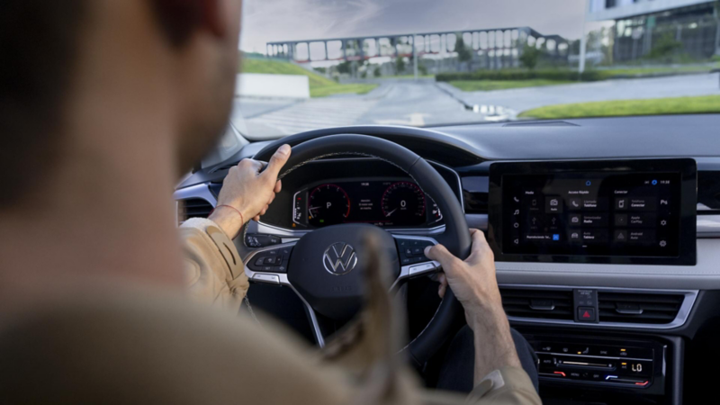 Conductor de un auto Volkswagen sujeta volante multifunciones.
