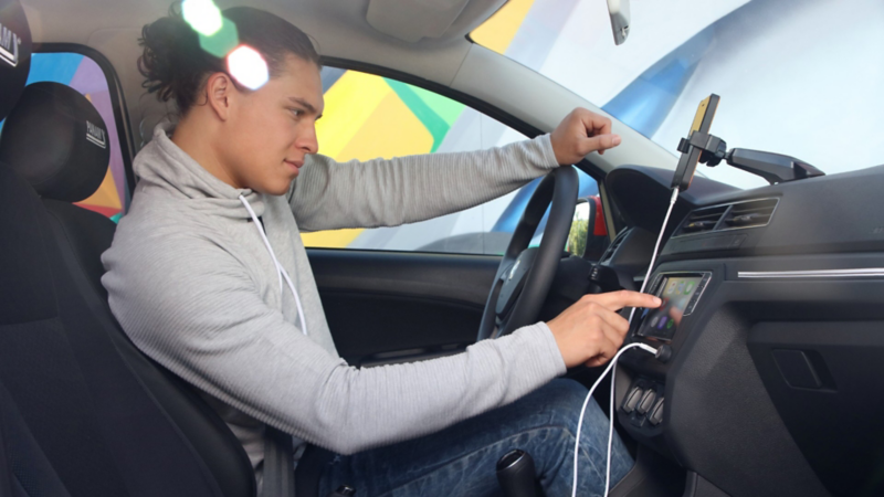 Conductor de auto VW escuchando consejos y tendencias en el podcast Radio Volkswagen