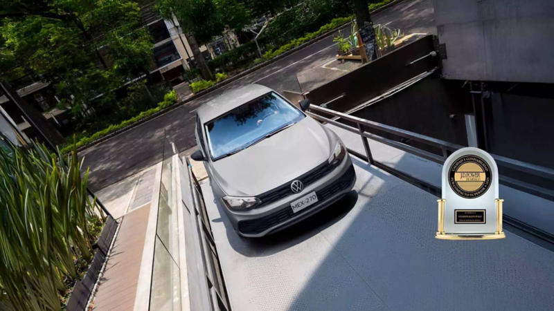 Volkswagen Polo versión Track de color gris sube una rampa de edificio moderno. 