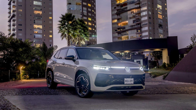 Camioneta Tiguan 2025 sale de conjunto residencial al atardecer. 