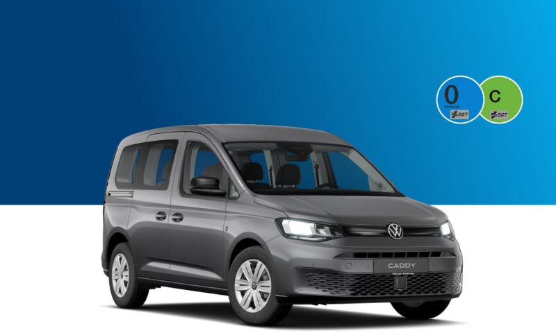 Una Caddy de ocasión negra de Volkswagen con las etiquetas de la DGT sobre un fondo azul y blanco