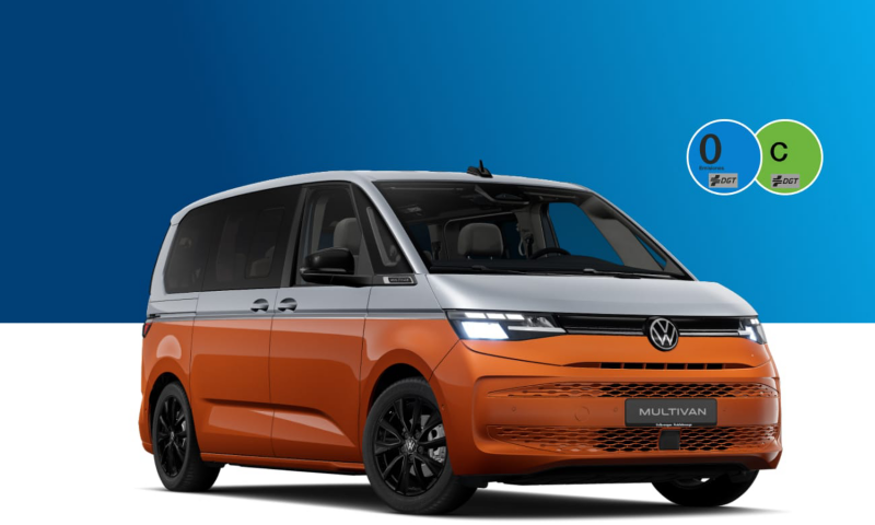 Una Multivan de ocasión de Volkswagen con las etiquetas de la DGT sobre un fondo azul y blanco