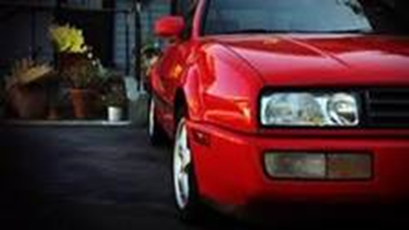 Detailsho van de linker voorzijde van een oude rode Volkswagen Corrado