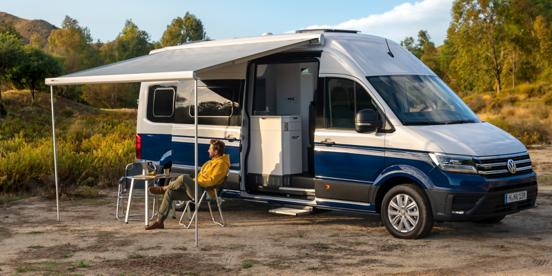 The Grand California with the awning open and camping furniture.